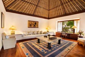 a living room with a couch and a table at The Oberoi Beach Resort, Lombok in Tanjung