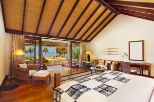 a bedroom with a bed and a living room at The Oberoi Beach Resort, Lombok in Tanjung