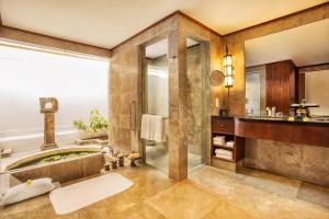 a bathroom with a tub and a sink at The Oberoi Beach Resort, Lombok in Tanjung