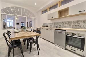 a large kitchen with a wooden table and chairs at La Veore - Baby-foot in Chabeuil