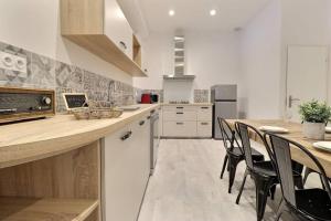 a kitchen with a table and chairs and a counter at La Veore - Baby-foot in Chabeuil