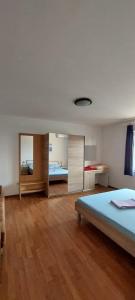 una grande camera con un letto e uno specchio di Apartments Zoran a Povljana (Pogliana)
