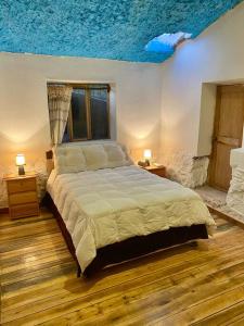 a bedroom with a bed with a blue ceiling at Casas de campo para riders in Urubamba
