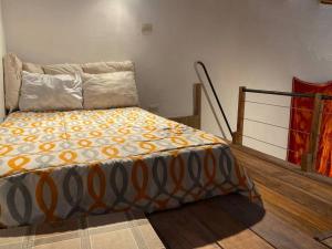 a bedroom with a bed with an orange and white blanket at Casas de campo para riders in Urubamba