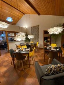 uma sala de jantar com mesas e cadeiras amarelas em CasAlê Come&Dorme em São Pedro da Serra