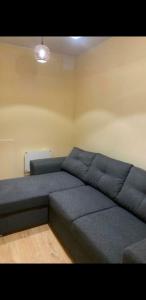 un grande divano blu in una stanza con una luce di Lauku street private apartment a Liepāja