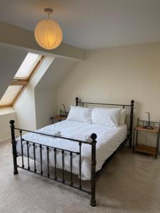 a bedroom with a bed with white sheets and a lamp at Family home close to Shrewsbury Town centre in Shrewsbury