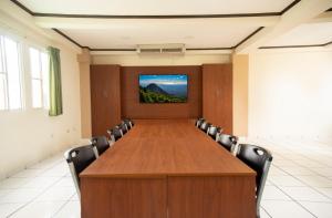 una sala de conferencias con una gran mesa de madera y sillas en Hotel Villa Serena San Benito, en San Salvador