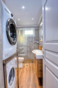 a bathroom with a washing machine and a washer at Stratos house! in Alepou