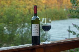 una botella de vino y una copa en un riel en Lar do Vale - Vinhedos, en Bento Gonçalves