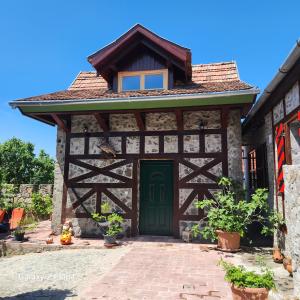 a building with a green door and a roof at Fácán-Lak in Nógrád