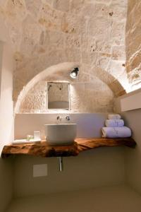 La salle de bains est pourvue d'un lavabo et d'un miroir. dans l'établissement Trulli di Titti - Country House, à Castellana Grotte