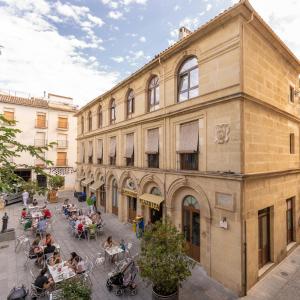 un grupo de personas sentadas fuera de un edificio en Casa el Aguardentero en Alcalá la Real