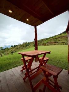 a picnic table and a bench on a porch at Finca La Gozadera in Jardín +5 photos