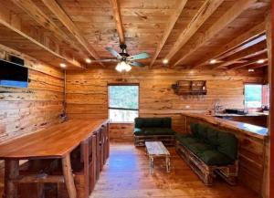 a log cabin with a bar and a ceiling fan at Finca La Gozadera in Jardín