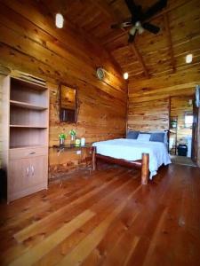 a bedroom with a bed in a wooden cabin at Finca La Gozadera in Jardín