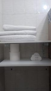 a shelf with towels and a pile of towels at LUANTO in Conil de la Frontera
