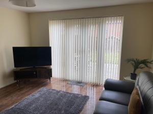 a living room with a couch and a large window at Family home close to Shrewsbury Town centre in Shrewsbury