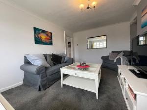 a living room with a couch and a table at Seaside sanctuary in Pakefield