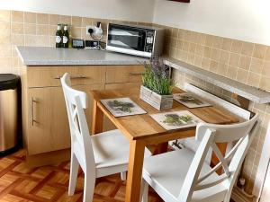 a kitchen with a wooden table and a microwave at Seaside sanctuary in Pakefield