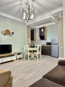 een woonkamer met een tafel en een keuken bij Aparthotel Kutaisi in Koetaisi
