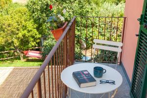 a table with a book and glasses on a balcony at La Casa dei Glicini in Levanto