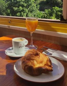 una mesa con un plato de pan y un vaso de zumo de naranja en Hostal Los Valles en Bielsa