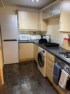 a kitchen with a white refrigerator and a dishwasher at Family home close to Shrewsbury Town centre in Shrewsbury