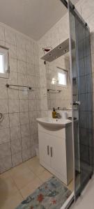 bagno con lavandino e doccia di Apartments Zoran a Povljana (Pogliana)