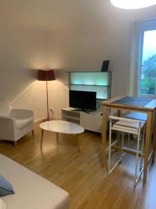a living room with a table and a desk with a computer at Studio à Noyarey avec wifi in Noyarey