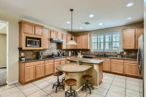 a kitchen with wooden cabinets and a island with bar stools at The Winner's Getaway in Las Vegas