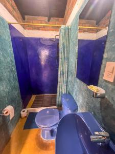 a bathroom with a blue toilet and a sink at Campground Hostal La Bonanza Chez Kika in Piendamó