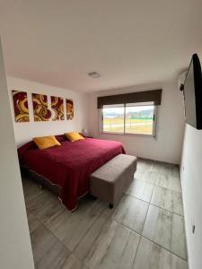 1 dormitorio con cama roja y ventana en Super Casa en Los Molinos PREVIAJE in 