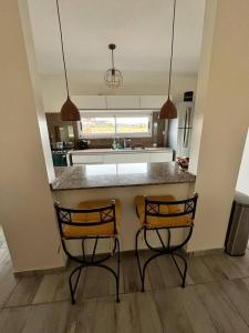 2 sillas sentadas en un mostrador de cocina en una cocina en Super Casa en Los Molinos PREVIAJE in 