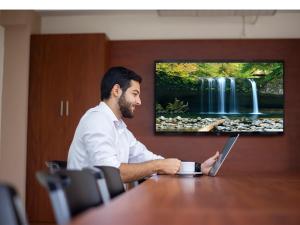 a man sitting at a table with a laptop at Hotel Villa Serena San Benito in San Salvador