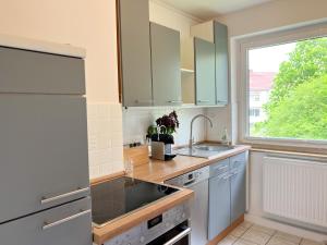 a kitchen with a sink and a refrigerator and a window at New-York Appartment, 2 Zimmer, Zentral Nähe Bahnhof Wilhelmshöhe in Kassel