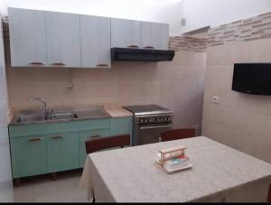 a kitchen with a table and a sink and a stove at Locazione turistica messapi in Manduria