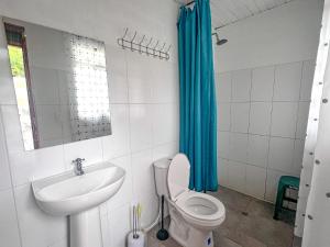 a bathroom with a toilet and a sink at Campground Hostal La Bonanza Chez Kika in Piendamó