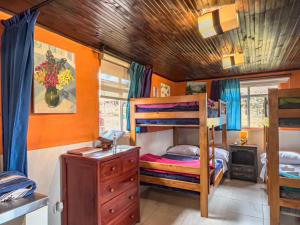 a bedroom with bunk beds and a wooden ceiling at Campground Hostal La Bonanza Chez Kika in Piendamó