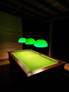 a pool table in a dark room with green lighting at Masia Cal Lloa in Albinyana