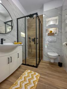 een badkamer met een douche, een wastafel en een toilet bij Apartments Kolovrat in Podstrana