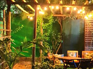 un patio con tavolo e alcune piante e luci di Di Pipa Rooms - Hidromassagem Externa a Pipa
