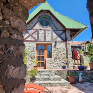 une maison en pierre avec un toit vert dans l'établissement Fácán-Lak, à Nógrád