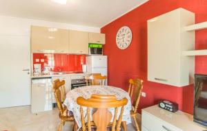 a kitchen with a table and chairs and a clock on the wall at Apartment Ina in Povlja +13 photos