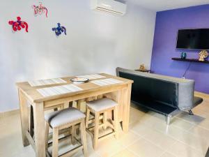 ein Esszimmer mit einem Tisch und Stühlen sowie einem TV in der Unterkunft Casa Puerto Morelos Riviera Maya in Puerto Morelos