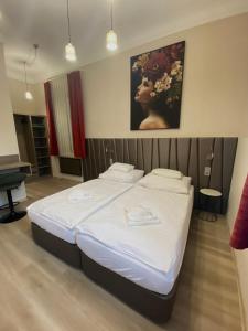 um quarto com uma cama com um quadro na parede em Pető Apartman em Gyor
