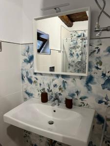 ein Bad mit einem Waschbecken und einem Spiegel in der Unterkunft CilentoAndMORE - Dai Puddicchi - Cilento House in Cuccaro Vetere