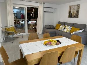 a living room with a table with a bowl of fruit on it at NEW STYLISH BEACH FRONT APARTMENT in Cullera +12 photos