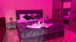 a pink bedroom with two pink flamingos on a bed at Petra Rose Apartment in Wadi Musa