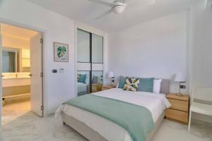 プンタ・カナにあるLuxury Apartment at Cana Rock Star Punta Cana DRの白いベッドルーム(ベッド1台、バスルーム付) +44枚の写真